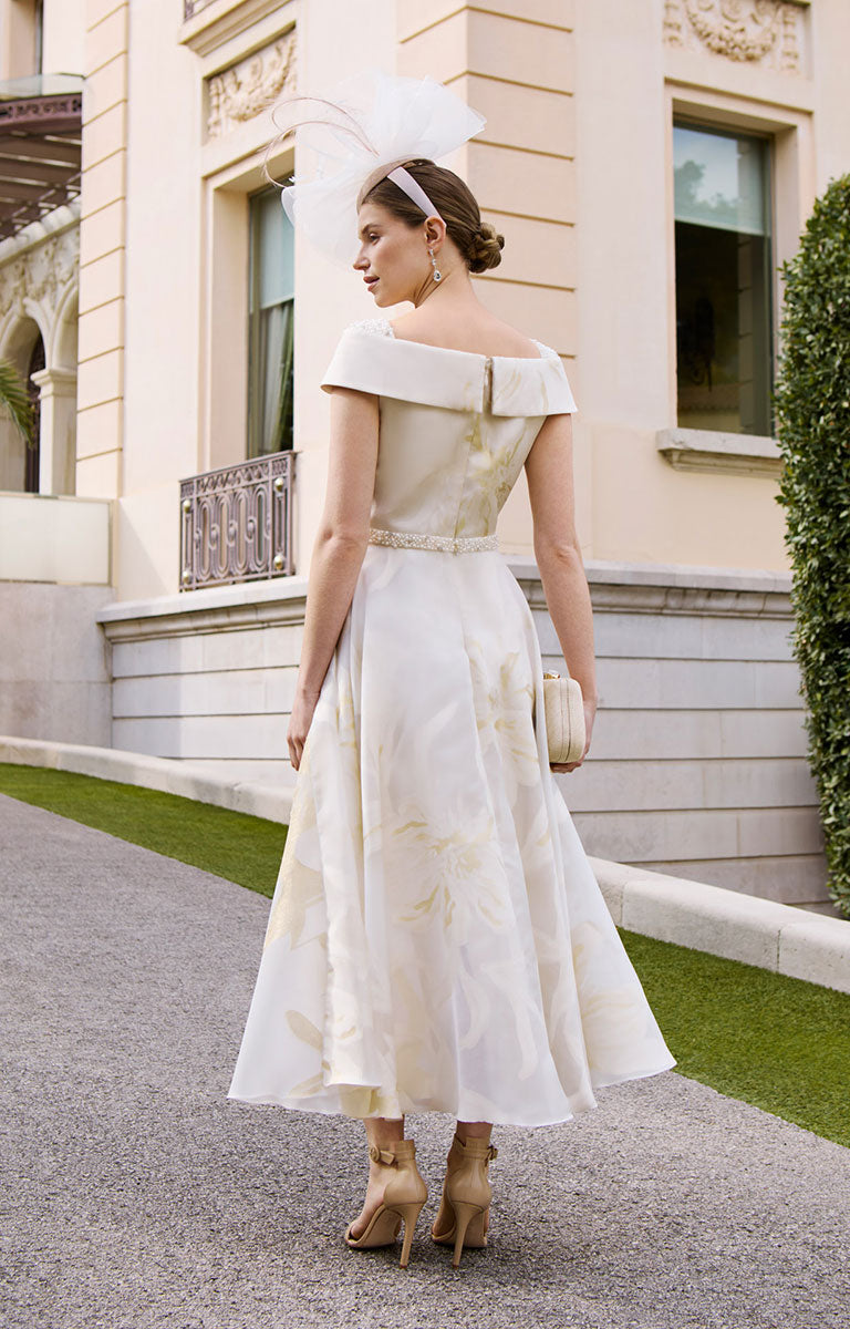 Woman in Couture Club by Rosa Clará 1GD1 - Cream Beaded Midi Dress for the Mother of the Bride or Groom standing in front of a building