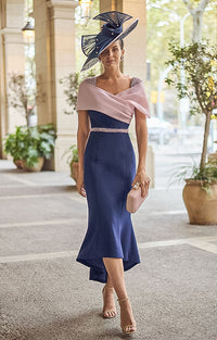 Woman wearing Couture Club 2G13 - Navy and Pale Rose Crepe Midi Dress with Elegant Colour-Block Design against an elegant courtyard background  with potted olive trees.