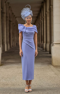 Woman in Couture Club 2G15 - Lavender Crepe Occasion Dress with Timeless Feminine Elegance and matching headpiece standing in an architectural setting.