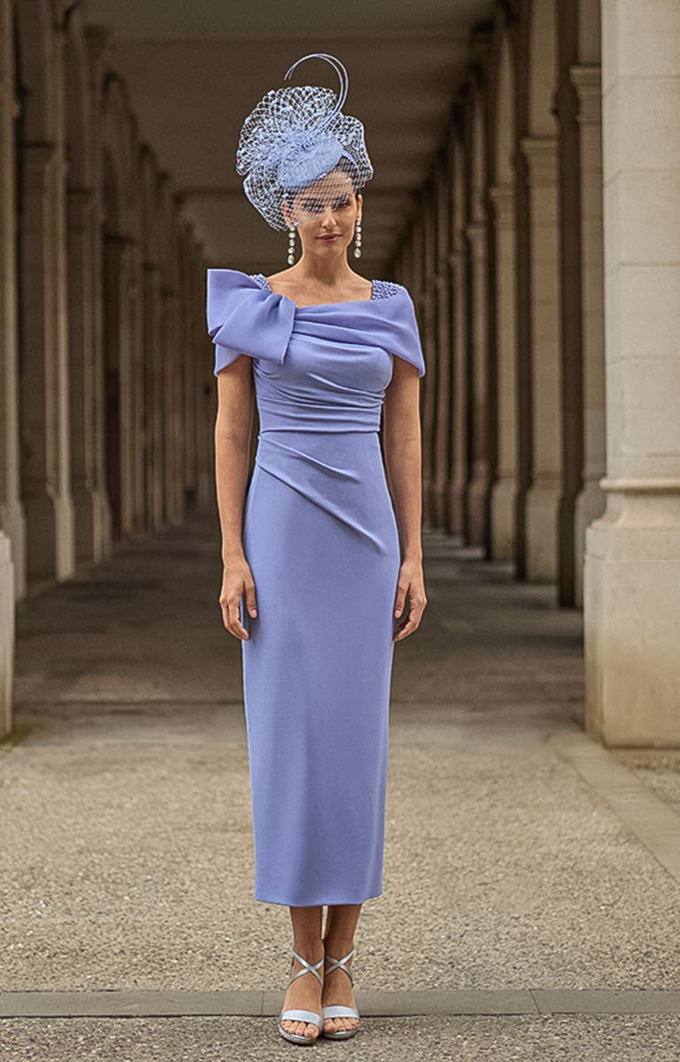 Woman in Couture Club 2G15 - Lavender Crepe Occasion Dress with Timeless Feminine Elegance and matching headpiece standing in an architectural setting.