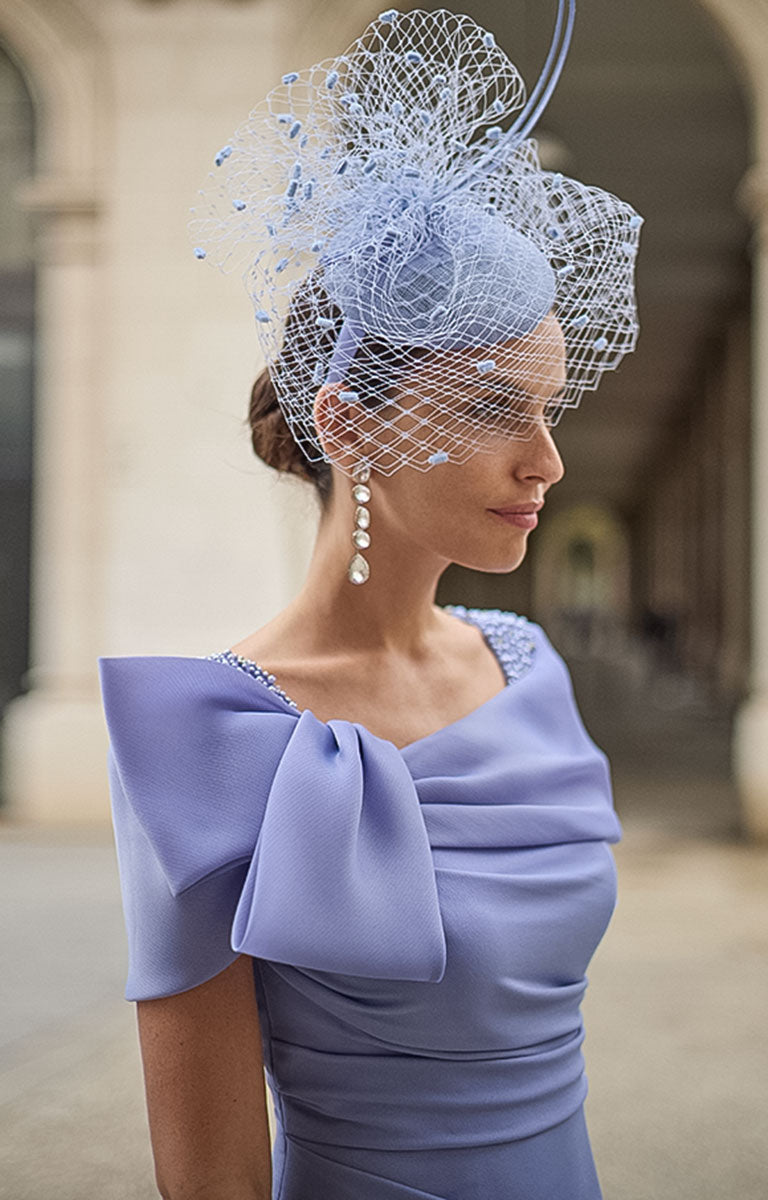 Woman wearing Couture Club 2G15 - Lavender Crepe Occasion Dress with Timeless Feminine Elegance with a decorative headpiece in an outdoor setting.
