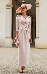 Woman in Couture Club 2G20 - Rosa Pastel Pink Crepe Occasion Dress with Timeless Feminine Styling with a matching hat standing in front of classical architecture.