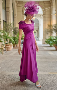 Woman wearing Couture Club 2G26 - Aubergine Crepe and Satin Occasion Dress with Elegant Tailored Silhouette in a beautiful courtyard setting with large potted plants. 