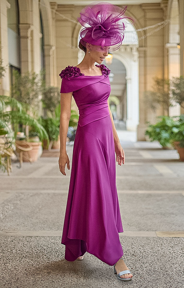 Woman wearing Couture Club 2G26 - Aubergine Crepe and Satin Occasion Dress with Elegant Tailored Silhouette in a beautiful courtyard setting with large potted plants. 