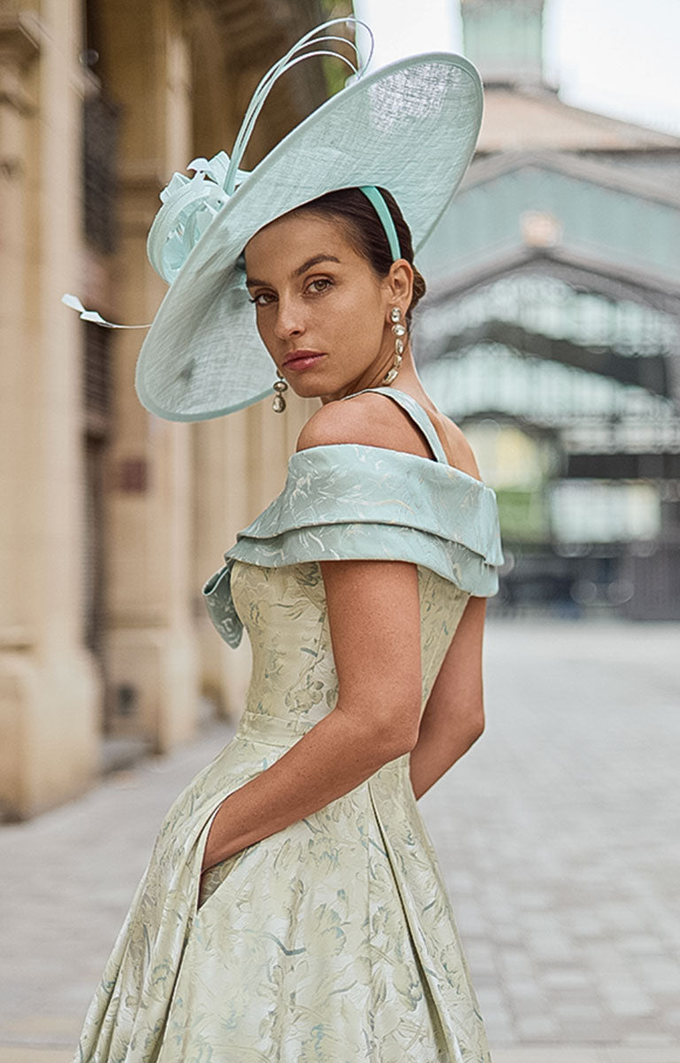 Woman wearing Couture Club 2G35 - Matcha Brocade Occasion Dress with Structured Silhouette mother of the bride / groom dress in an elegant street setting.